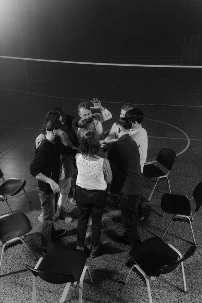 Grayscale Photo of People Standing on Gray Concrete Floor